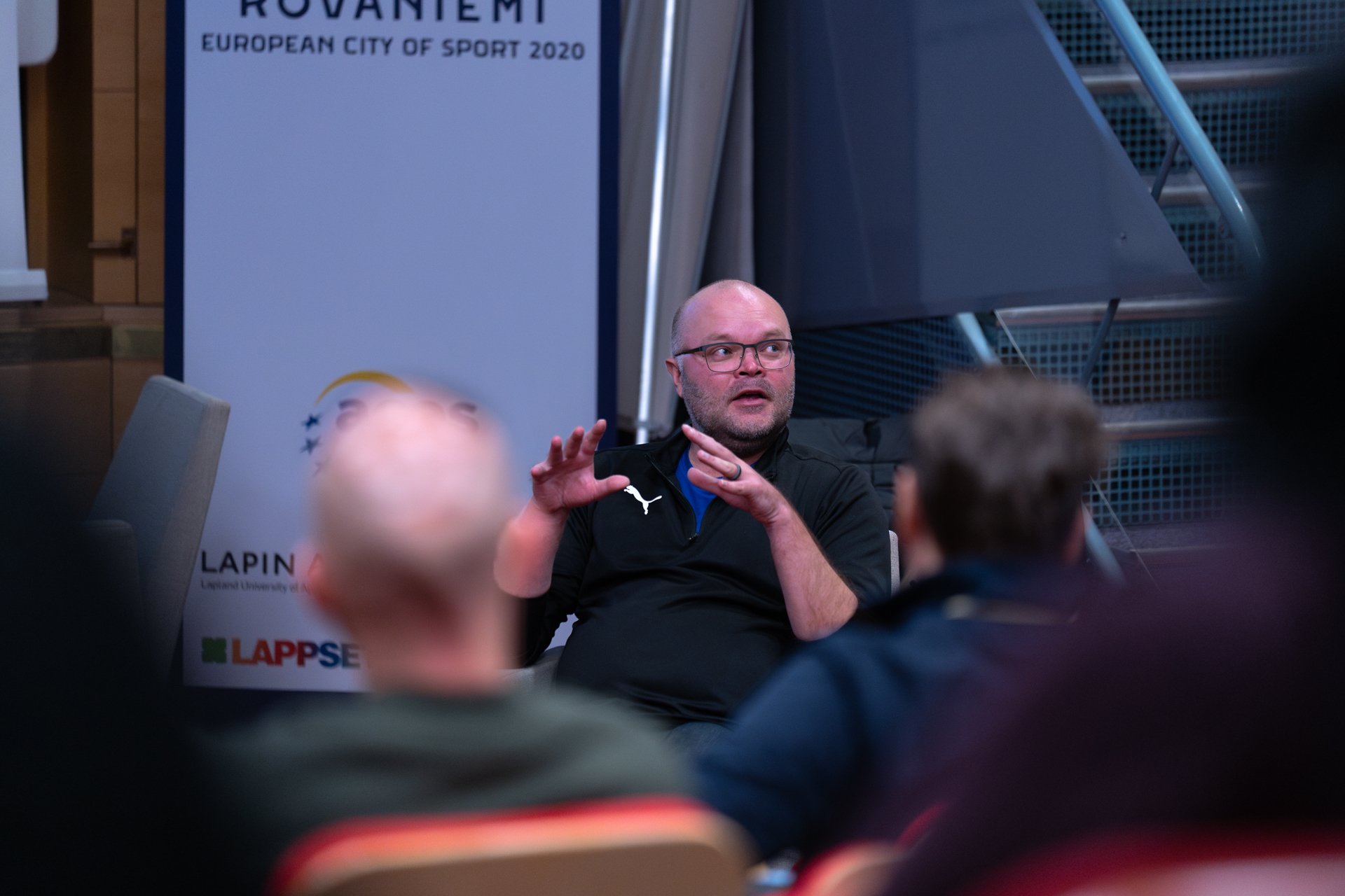 mies puhuu yleisölle